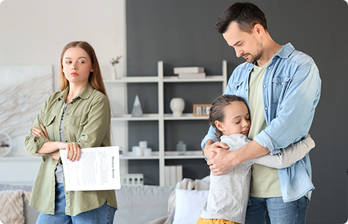 Unhappy woman with court papers stands apart as man hugs child.