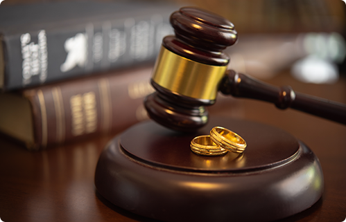 Marriage rings and law book next to a legal gavel.
